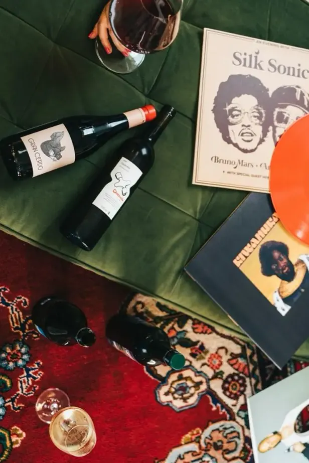 Red wine bottles and vinyl records on a patterned rug